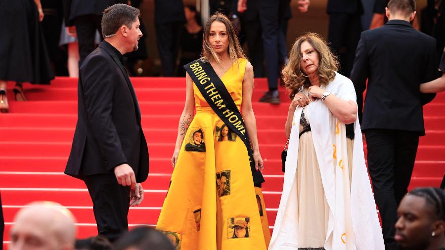 Laura Blajman-Kadar, sobrevivente dos ataques de 7 de outubro por militantes palestinos do Hamas, usa um lenço com os dizeres "Traga-os para casa" ao chegar para a exibição do filme "Furiosa: A Mad Max Saga" na 77ª edição do Cannes Film Festival, em Cannes