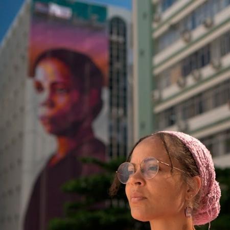 Artista Gugie em frente ao Edifício com pintura de Antonieta