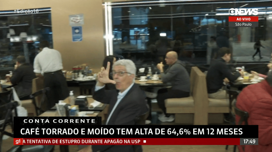 Homem faz gesto da letra L com a mão direita durante reportagem da GloboNews ao vivo - Reprodução/ GloboNews