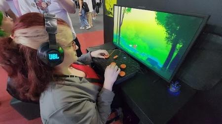 Jovem com deficiência usa controles adaptados para jogar videogame