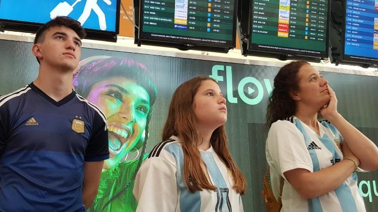 De izquierda a derecha, Felipe, Renata y Verónica Hodola.  El joven saldría a las 21 hs rumbo a Estados Unidos, pero llegó con su familia al aeropuerto a las 15 hs para ver el partido allí - Luciana Taddeo/UOL - Luciana Taddeo/UOL