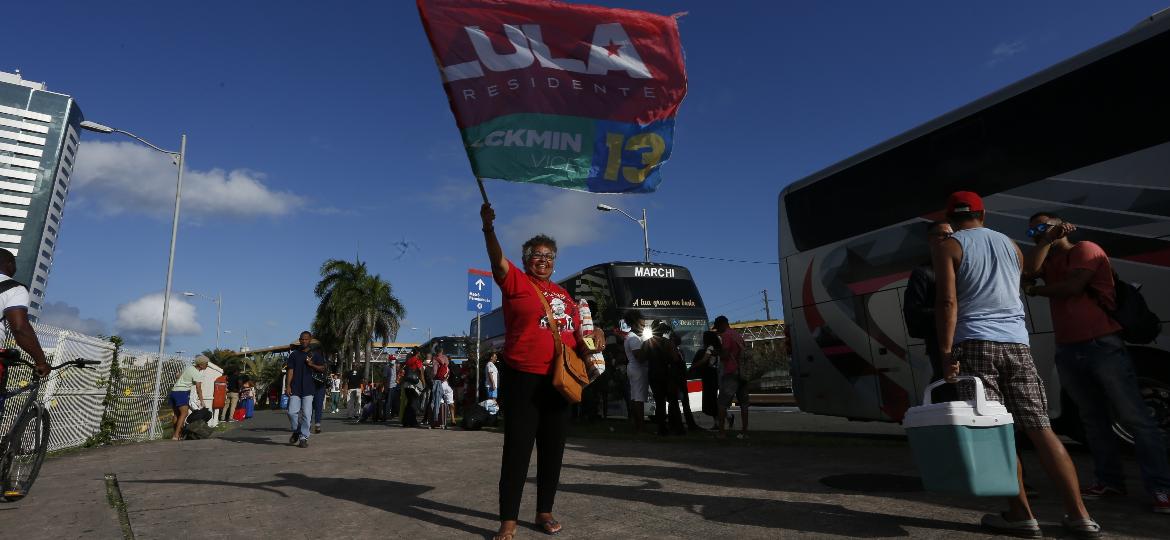 Apoiadora de Lula com bandeira em Salvador, no ponto de saída de uma caravana de 143 pessoas rumo à posse de Lula em Brasília - Olga Leiria/UOL