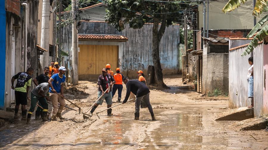Pessoas trabalham na retirada da lama das ruas após tempestades no litoral norte de São Paulo - Keiny Andrade/UOL