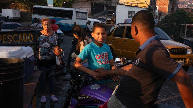 Clientes esperam na fila para comprar pescados em Caracas