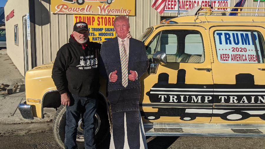 O americano Bob Langdon ao lado do seu Trump de papelão, que ele comprou online. O mecânico de 71 anos faz pose em frente ao seu Trump-Mobile, um carro modificado de oito portas, estacionado na sua mecânica em Powell, cidade de 6 mil habitantes em Wyoming - Fernanda Ezabella