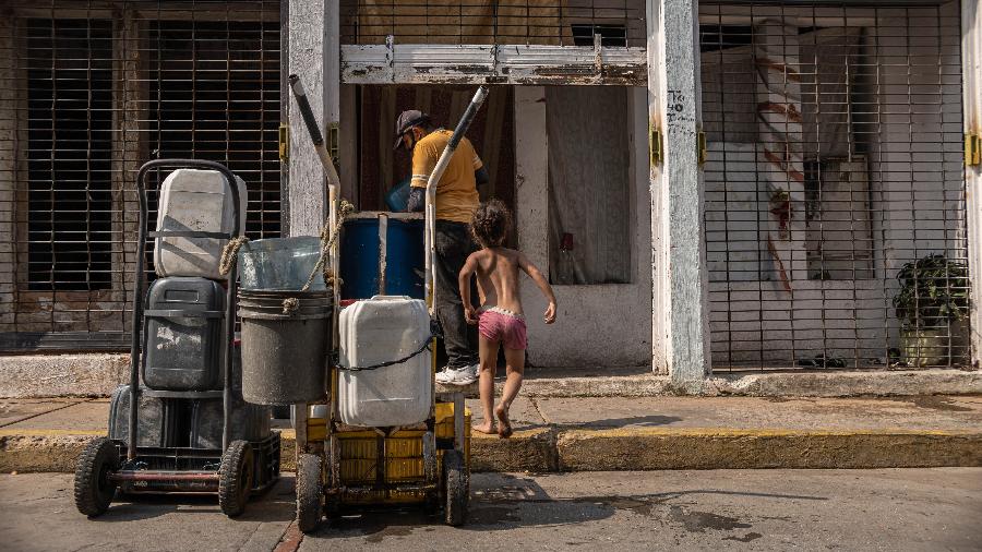 Juan Romero faz entrega de água em Maracaibo. Água encanada só chega uma vez ao mês na região, e a maioria dos moradores se abastece com água trazida por caminhões-pipa