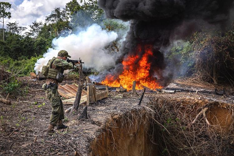 Servidor do Ibama atira com fuzil para inutilizar um motor usado em um garimpo ilegal recem aberto na terra indigena yanomami em Roraima