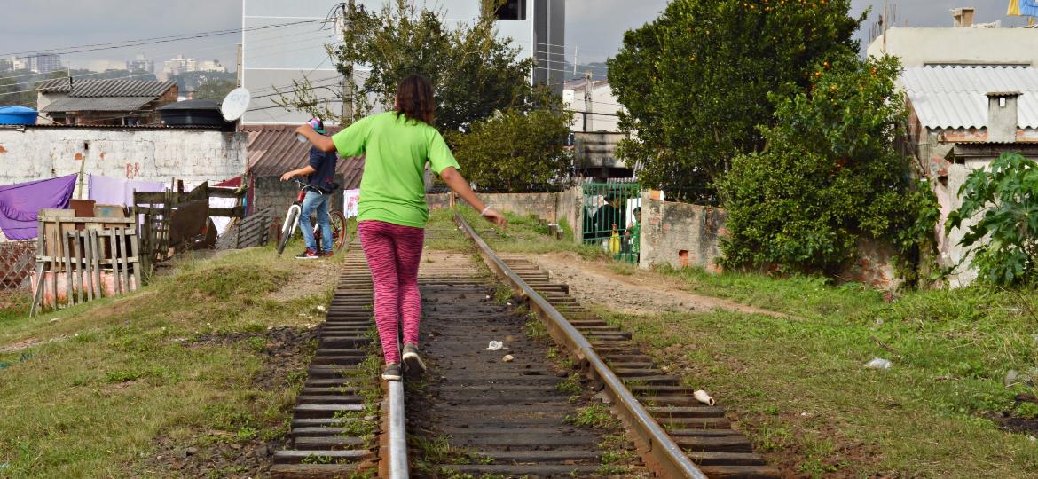 Adolescente atravessa os trilhos do trem na Vila Pantanal, em Curitiba - Amanda Andrade/UOL