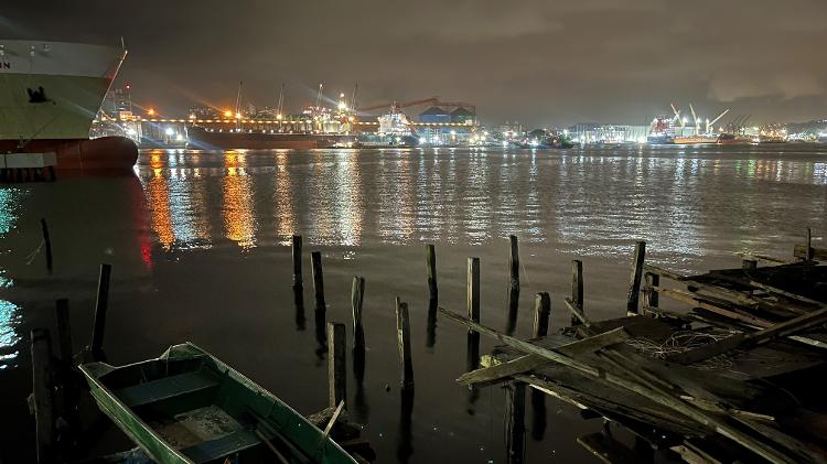 Favela de palafita no Guarujá; do outro lado, porto de Santos