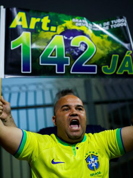 Com faixa que diz "Art. 142 Já", homem pede intervenção militar usando a camisa da seleção brasileira de futebol - Amanda Perobelli/Reuters