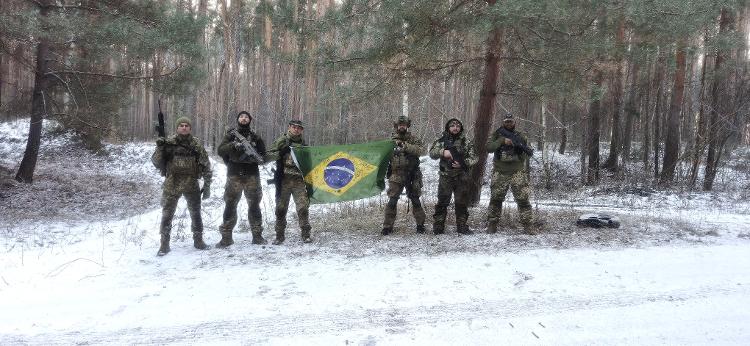 Brasileiros do exército ucraniano posam com bandeira nacional 