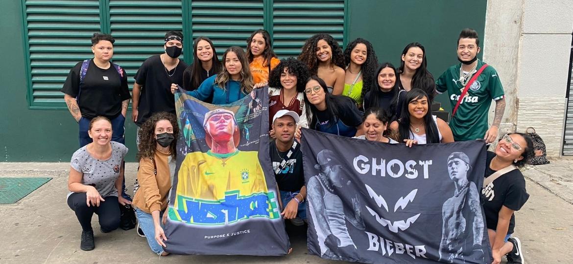 Claudia Andrade (atrás da bandeira "Ghost"), Gabriela Quesado (de óculos, à esq.) e outros fãs que estavam nas barracas B6 e B7 em frente ao Allianz Parque, à espera do show de Justin Bieber em São Paulo - Beatriz Trevisan/UOL