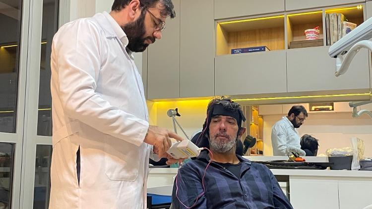 O neurocientista Ricardo Galhardoni controla corrente elétrica durante sessão de neuromodulação