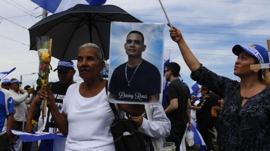 Em protesto d 2018 contra o governo de Daniel Ortega, mulher segura foto de seu filho morto, em Manágua, na Nicarágua - Anadolu Agency/Getty Images