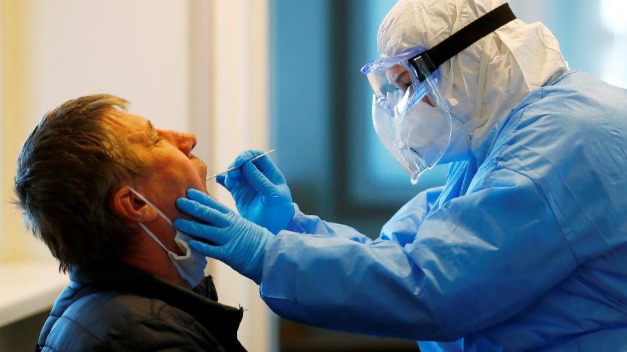 Profissional examina paciente para testar presença do novo coronavírus - Ints Kalnins/Reuters