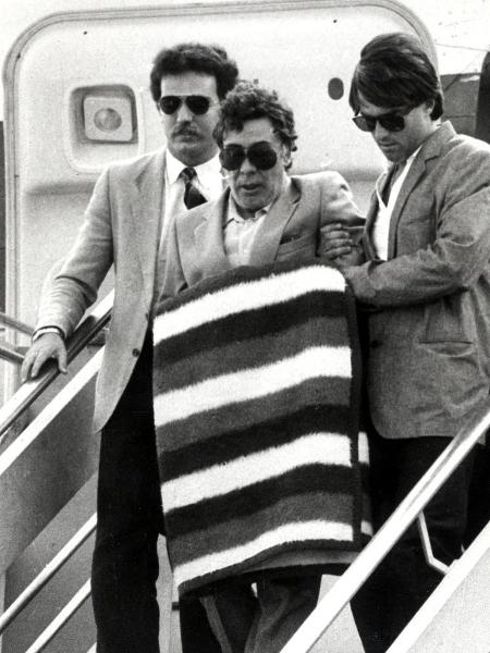 O ex-chefe da máfia siciliana Tommaso Buscetta, deixa avião escoltado no aeroporto Fiumicino, em Roma, em 1984