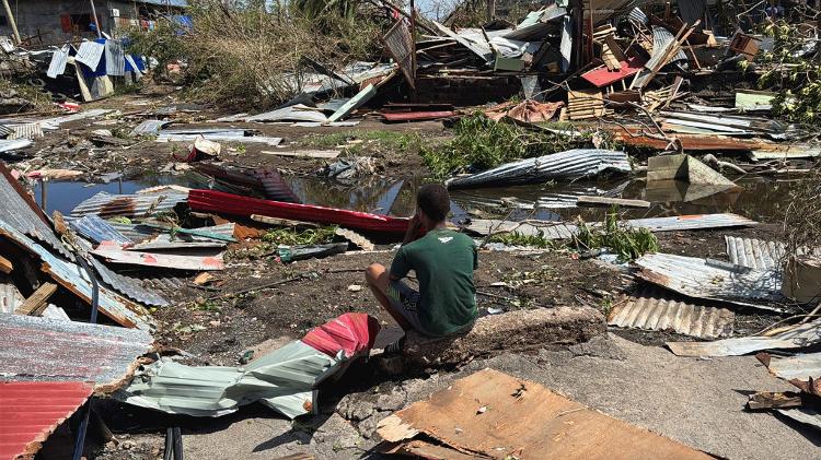 Menino observa as ruínas de casas, após o ciclone Chido, em Mayotte