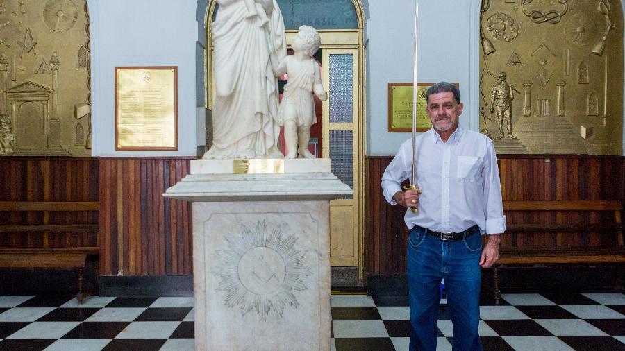 Felipe Chaves, 69, o "Cobridor Externo" do Grande Oriente do Brasil, ao lado da estátua que representa a Caridade - Matias Maxx/UOL