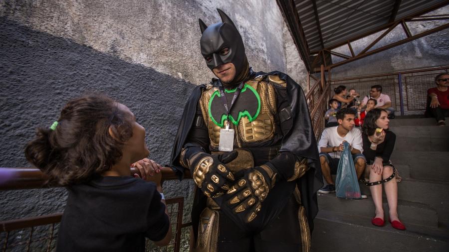 Criança conversa com cosplayer de Batman em cena flagrada durante a Perifacon de 2019, em São Paulo - André Lucas/UOL