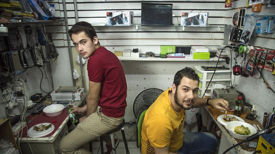 Os primos Ahmad Alnezame e Mouawia Juha, refugiados sírios que trabalham em estande rua Santa Ifigênia, em São Paulo - Jardiel Carvalho/UOL