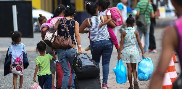 Grupo de adultos e crianças da Venezuela cruza a fronteira em Pacaraima, cidade ao norte de Roraima