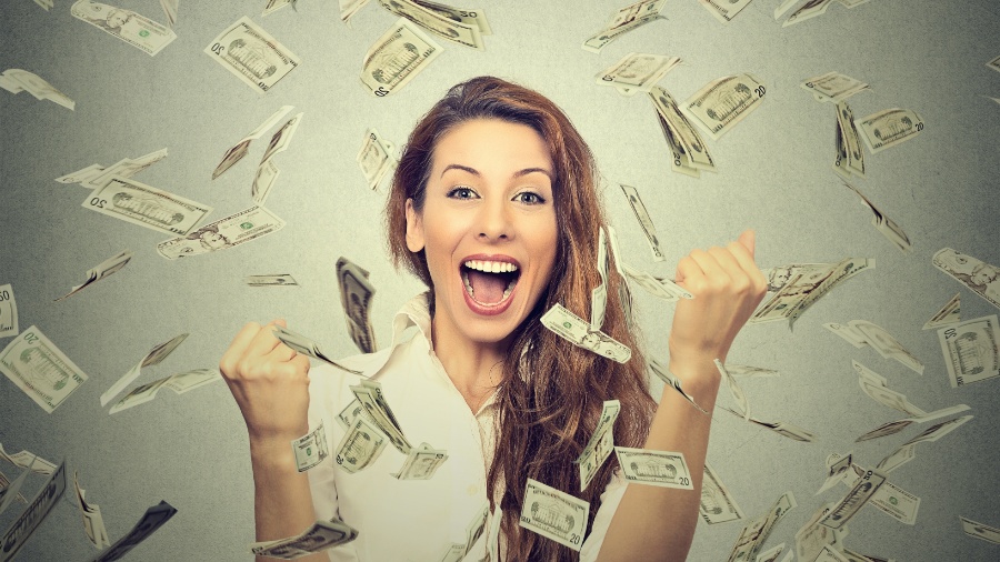 Mulher comemora chuva de dinheiro - Getty Images/iStockphoto