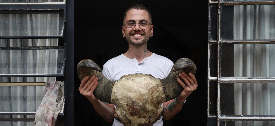 Lucas Miguel, 26, taxidermista paranaense, com uma cabeça de búfalo prestes a ser empalhada - Theo Marques/UOL