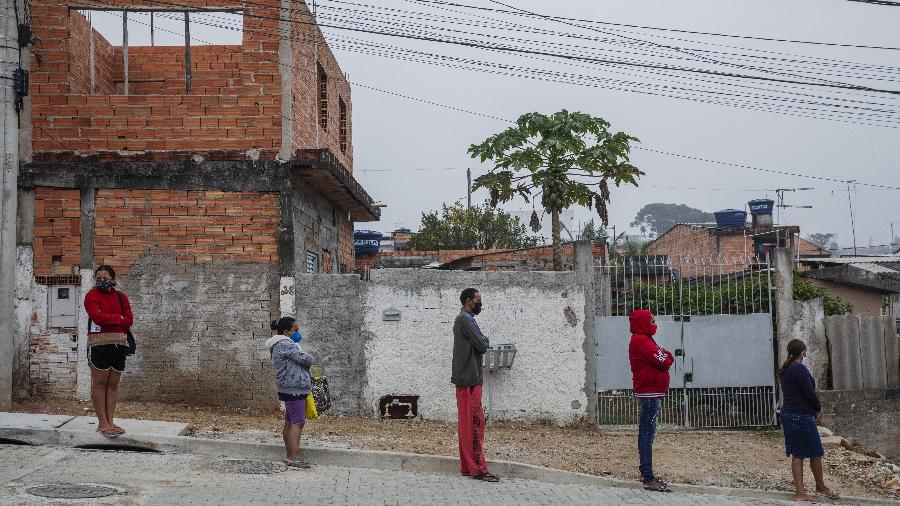 Moradores de Vargem Grande, região de Parelheiros no extremo sul de São Paulo, aguardam na fila para receber uma cesta básica doada pela Associação Pró-Brasil - Lalo de Almeida/Folhapress