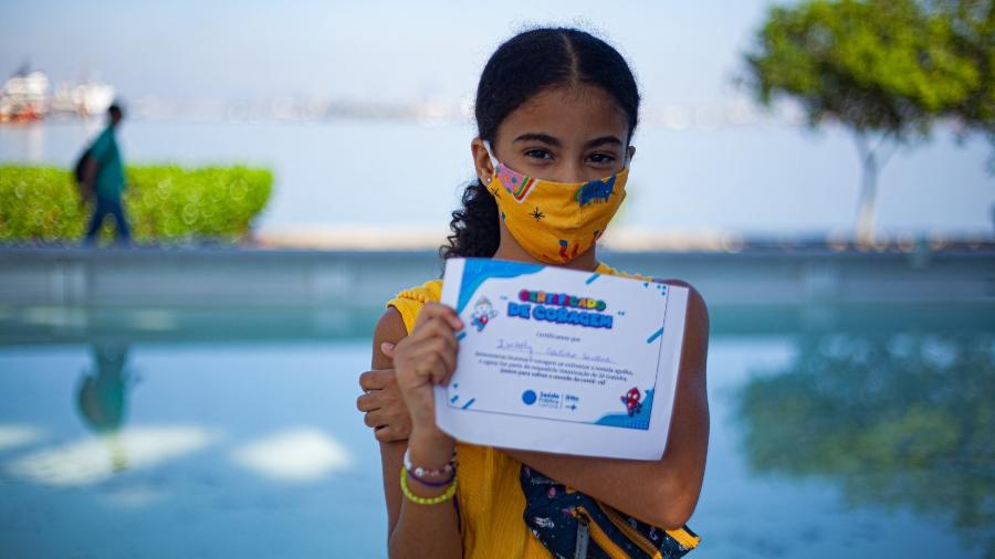 Isabela de Santana, 10, mostra seu "Certificado de Coragem" após ser vacinada no Museu do Amanhã, no Rio - Fabiana Batista/UOL