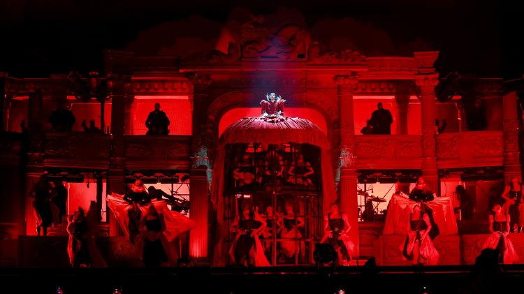 Vestido enorme de Gaga é "aberto" e revela duas fileiras de dançarinos em cenário de ópera vermelho; palco tem elementos que remetem ao "Fantasma da Ópera" Vestido enorme de Gaga é "aberto" e revela duas fileiras de dançarinos em cenário de ópera vermelho; palco tem elementos que remetem ao "Fantasma da Ópera"