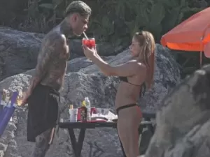 Flavia Saraiva dando bebida na boca de MC Cabelinho na praia