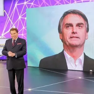Silvio Santos no palco do Teleton 2018 e foto de Bolsonaro