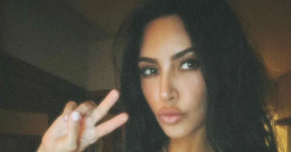 Kim Kardashian fazendo biquinho e o V com a mão