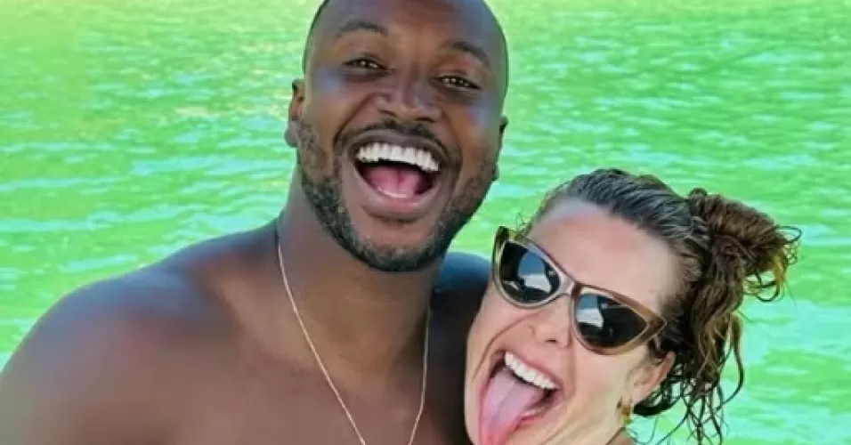 Thiaguinho e Fernanda Souza sorrindo com mar ao fundo