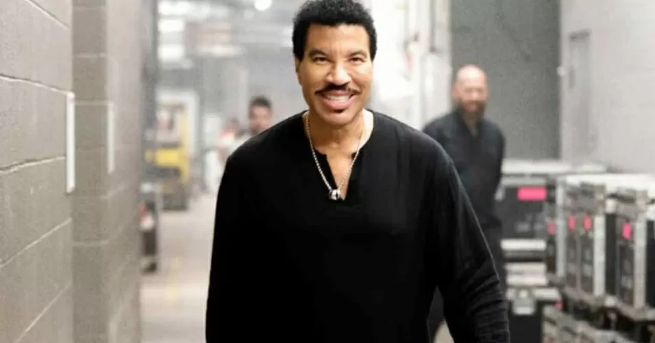 Lionel Richie de preto caminhando em backstage