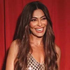 Juliana Paes sorrindo com fundo vermelho 