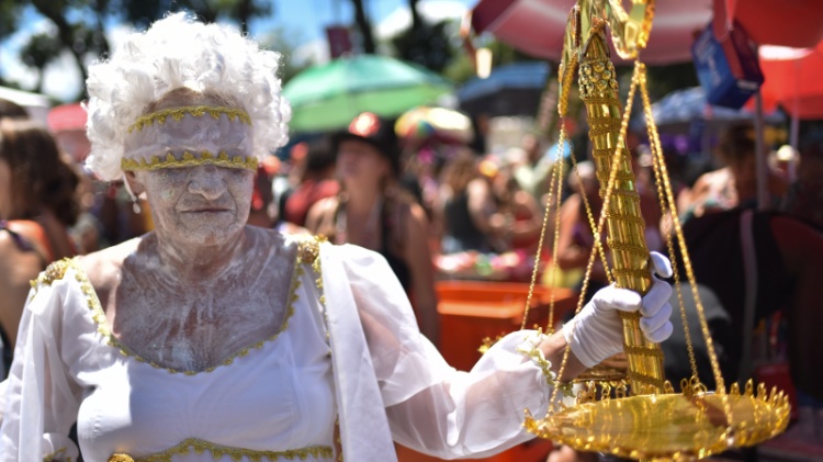 Senhora segura objeto dourado no Bloco Cordão do Boitatá, no Rio