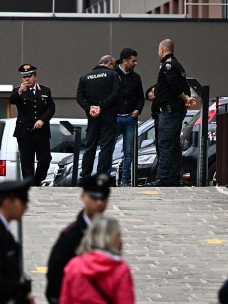 Policiais italianos e carabinieri se reúnem em frente a viaturas