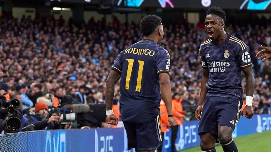 Rodrygo comemora com Vini Jr após marcar pelo Real Madrid contra o Manchester City