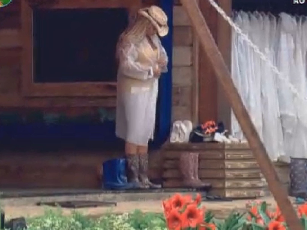 Em dia de garoa em Itu, Ângela Bismarchi veste capa de chuva antes de cuidar dos porcos (19/6/12)