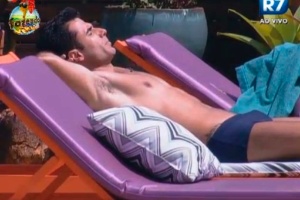 Dan toma banho de sol à beira da piscina 