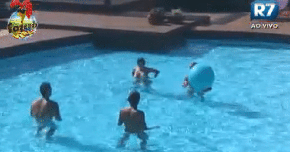 Peões brincam com bola na piscina