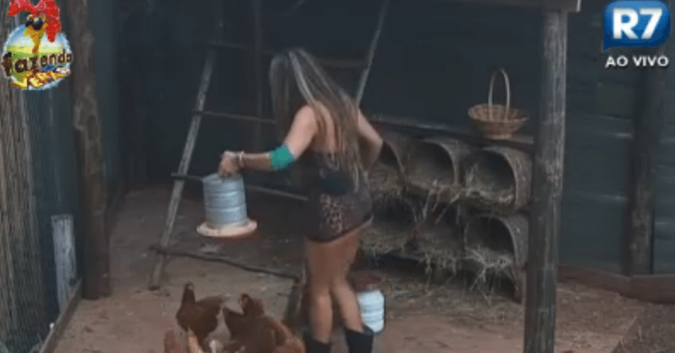 De pijamas, Manoella alimenta as galinhas pela manhã