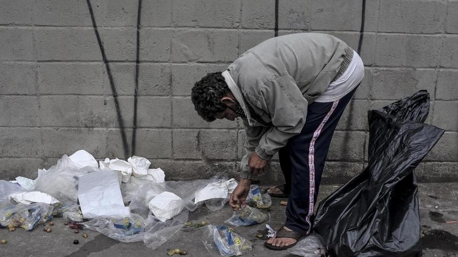 Morador procura resto de comida no lixo em São Paulo - Reinaldo Canato/UOL